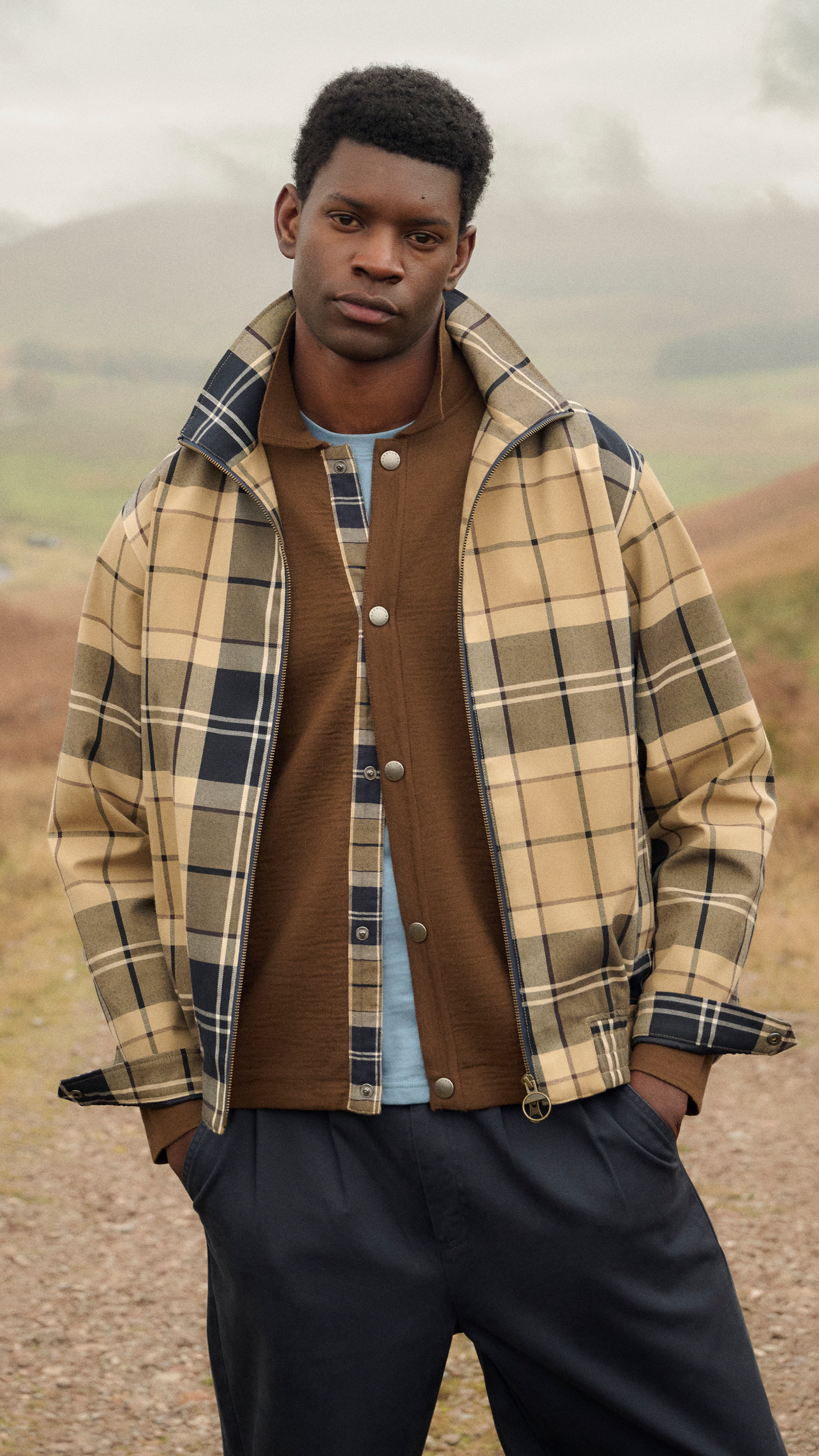 Man in beige plaid jacket modelling adaptable desk to dinner outfits outdoors